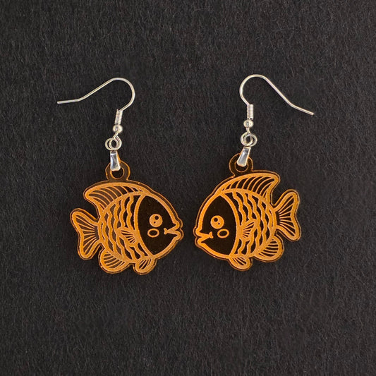 Handmade orange acrylic goldfish earrings with engraved detail, laser-cut and made to order, stainless steel hooks, shown on black background