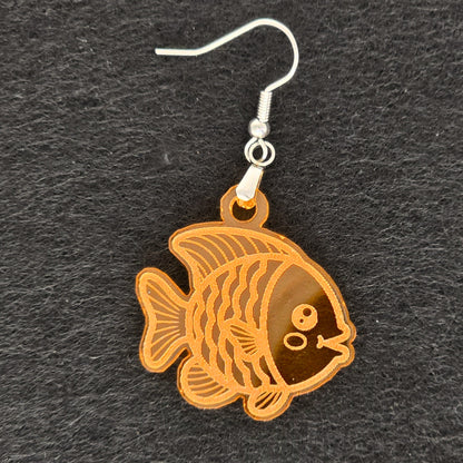 Detail shot of handmade orange acrylic goldfish earring, laser-cut with engraved scale and fin detail, stainless steel hook, shown on black background
