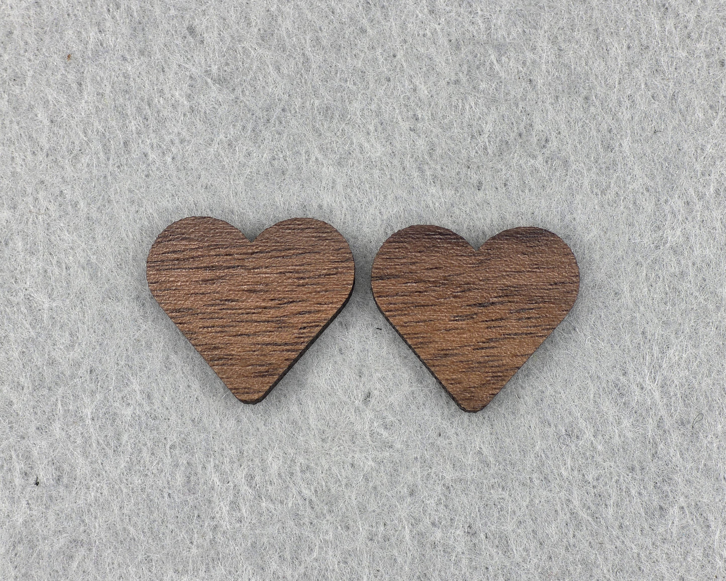 Close-up of walnut heart stud earrings showing wood grain texture, handmade wood earrings by Rainbow Charlie