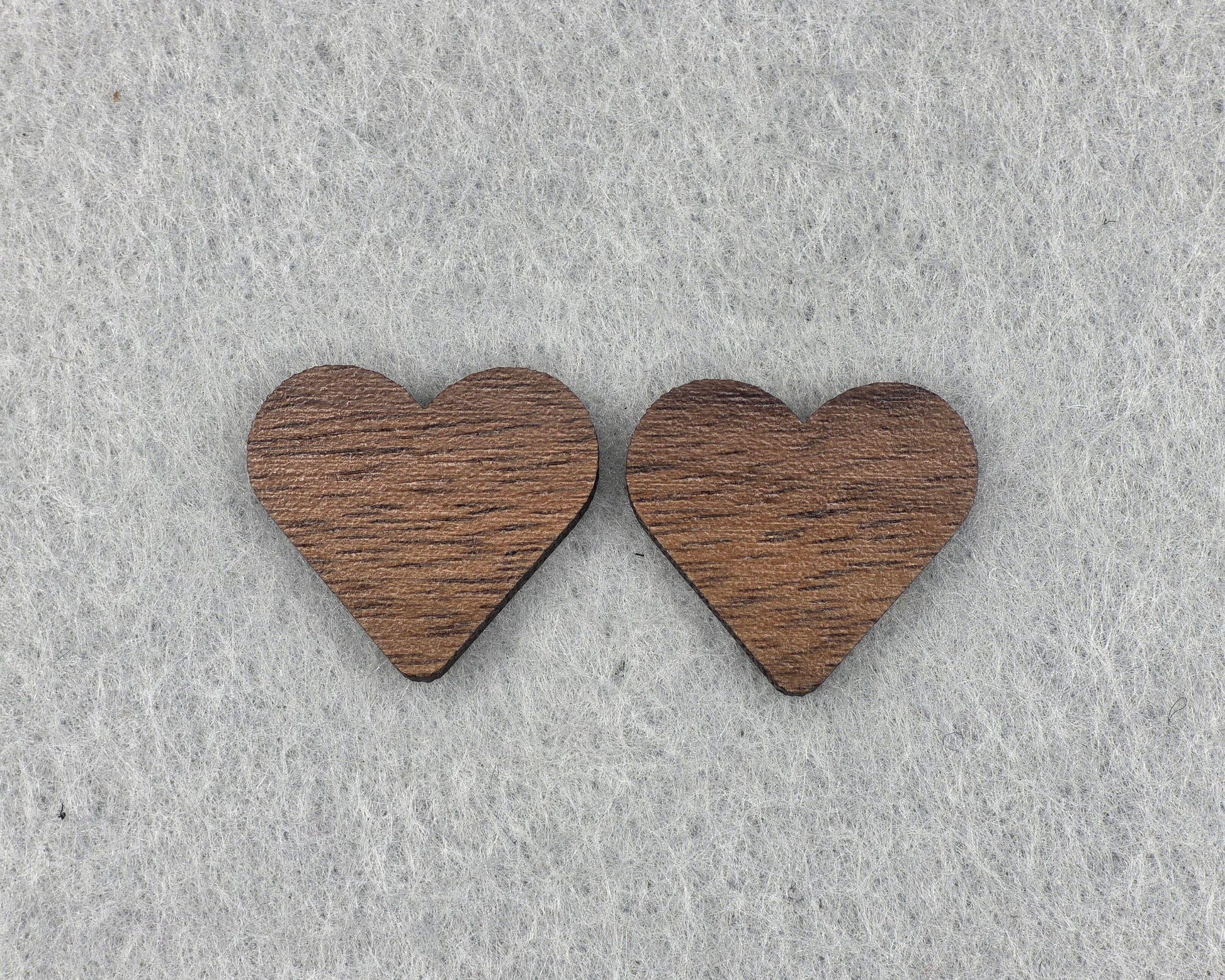 Close-up of walnut heart stud earrings showing wood grain texture, handmade wood earrings by Rainbow Charlie