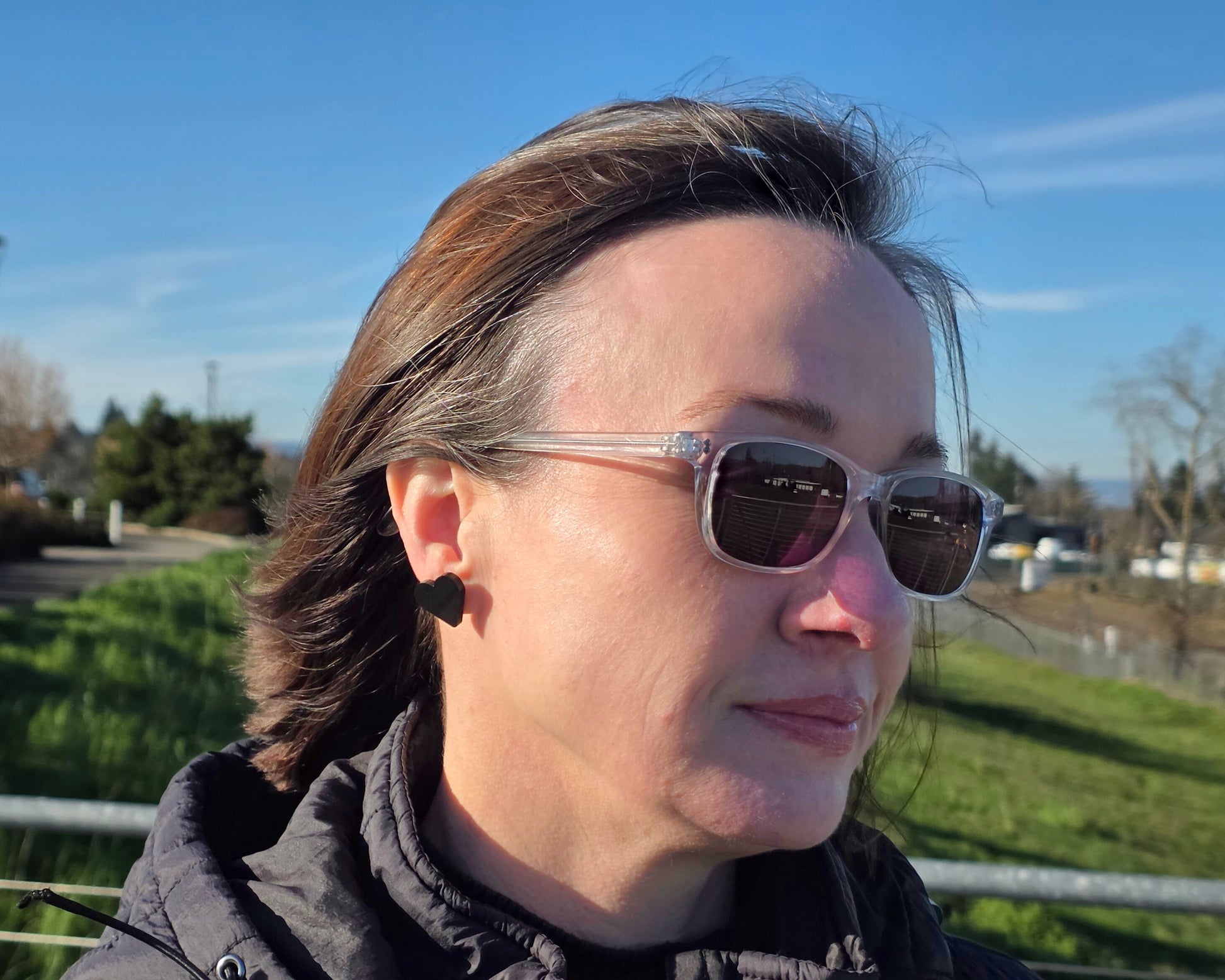 Black acrylic heart stud earring on ear, outdoor side view, lightweight everyday earrings with titanium posts