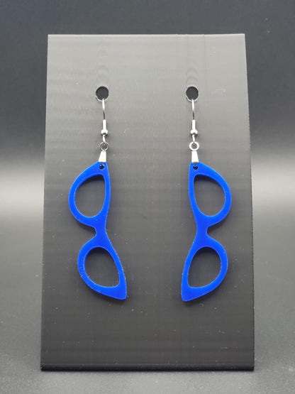 Blue acrylic cat-eye glasses dangle earrings on a matte black jewelry card. Handmade, laser-cut retro jewelry.