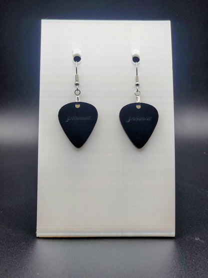 Black acrylic guitar pick earring with "Jasmine" engraved, shown on a white jewelry card. Fun, personalized jewelry for music lovers.