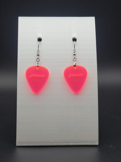 Fluorescent acrylic guitar pick earring with "Jasmine" engraved, shown on a white jewelry card. Fun, personalized jewelry for music lovers.