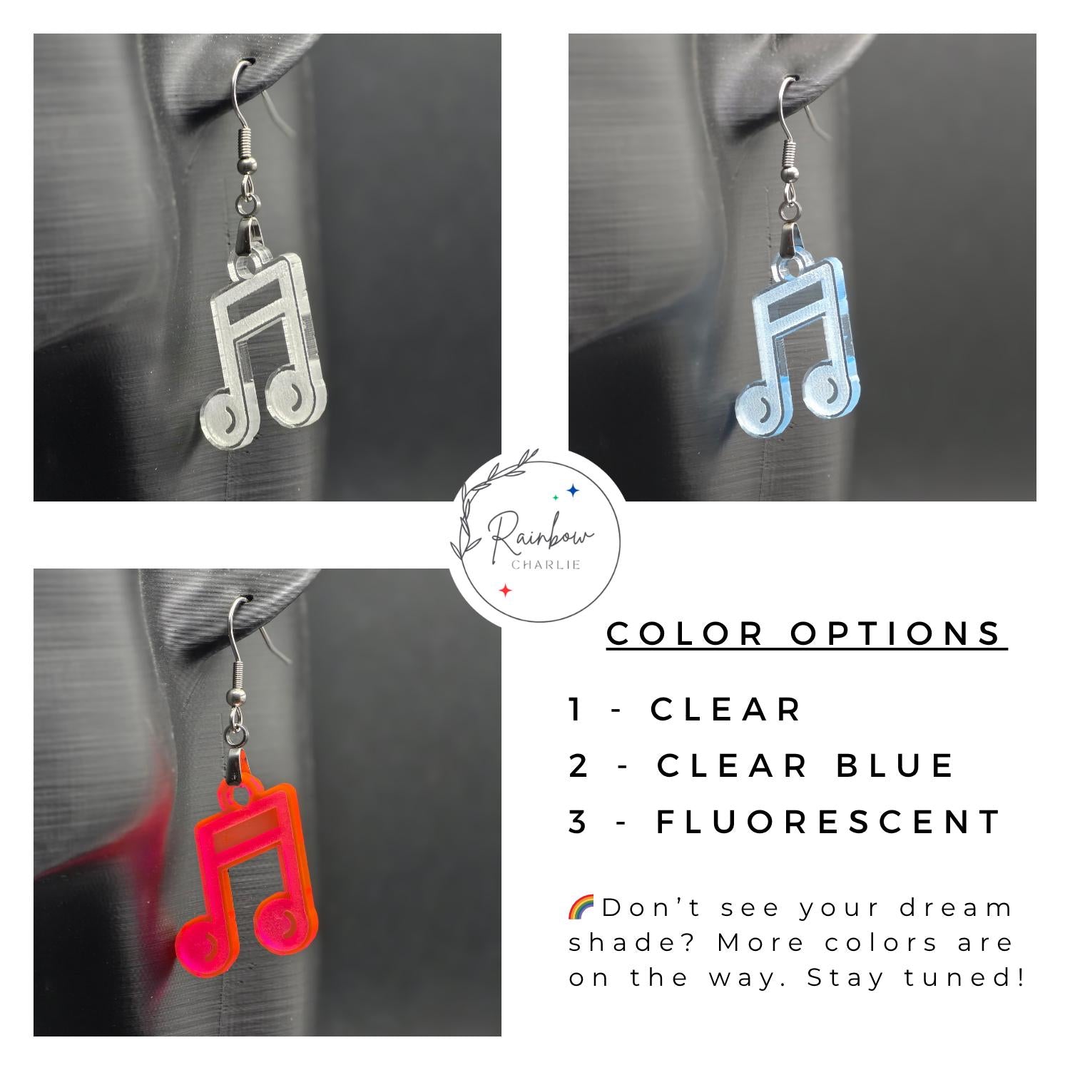 Three acrylic music note earrings shown on a mannequin ear in different colors: clear, clear blue, and fluorescent. Text on the image lists color options and mentions more coming soon. Rainbow Charlie logo in the corner.