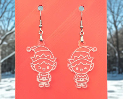Front view of frosted acrylic elf earrings with white engraved details, hanging from nickel-free hooks on a red display card.