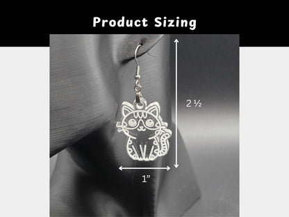 Close-up of a frosted acrylic cat earring hanging on a mannequin head. White measurement lines indicate the earring size: approximately 2.5 inches long and 1 inch wide.