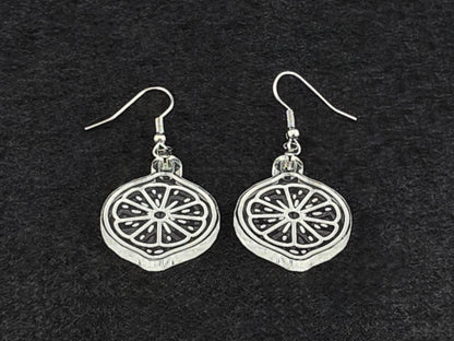 Clear acrylic lemon slice earrings shown at an angle, highlighting the engraved citrus detail and cut edge.